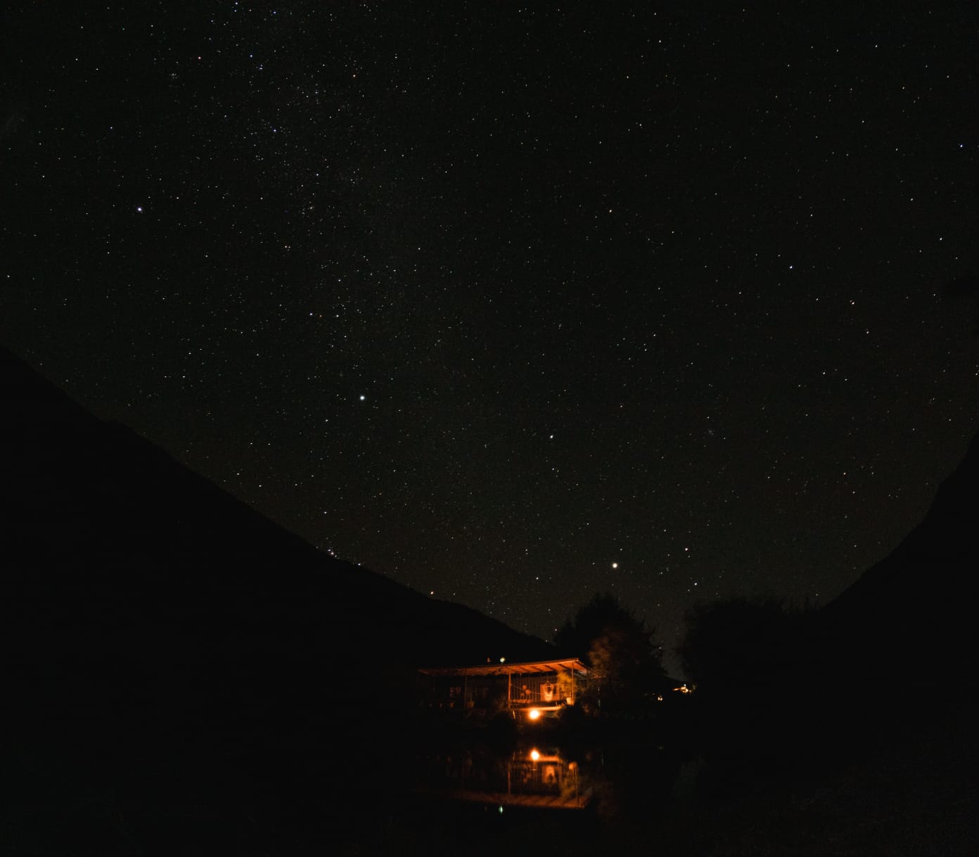 Cabin glowing under the Milky Way